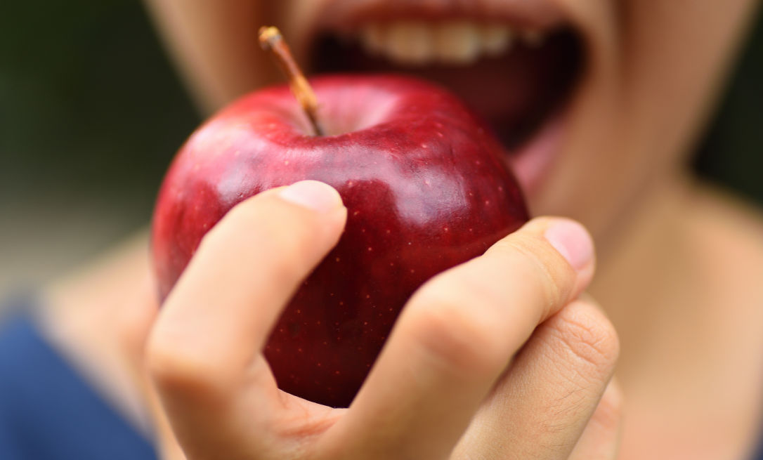Six ways to look after yourself in lockdown; woman eating apple